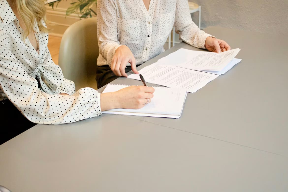American couple signing real estate closing documents with attorney